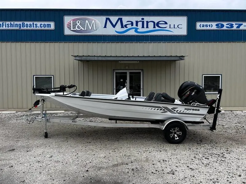 Slide: The Image of 2025 Xpress H18 Bass boat on trailer outside L&M Marine LLC building. - 0