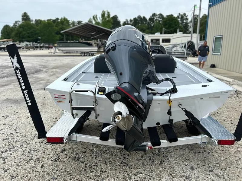 Slide: The Image of 2025 Xpress H18 Bass boat with outboard motor on trailer, parked outdoors. - 4
