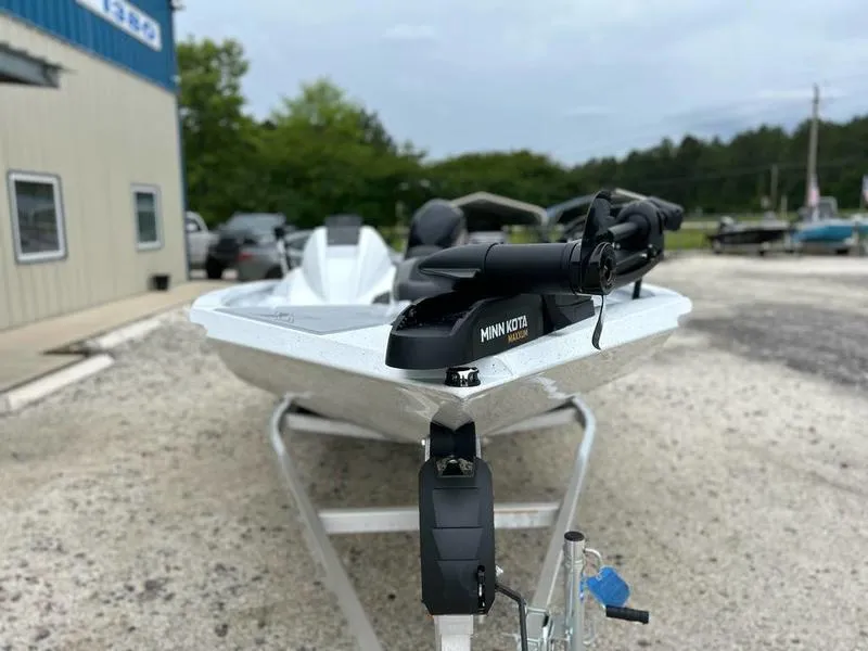 Slide: The Image of 2025 Xpress H18 Bass boat with Minn Kota motor on trailer, parked outdoors. - 5