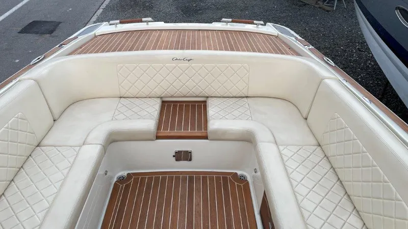 Slide: The Image of 2017 Chris-Craft Launch 28 boat interior with white quilted seating and wooden flooring. - 10