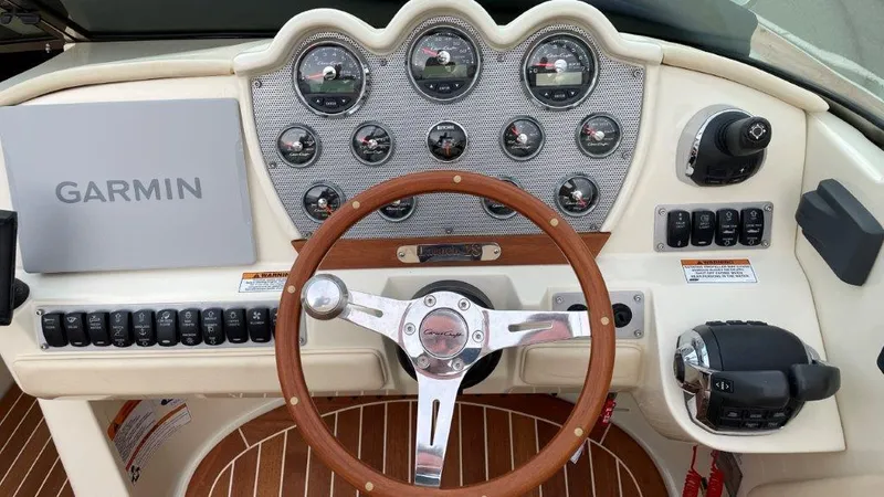 Slide: The Image of 2017 Chris-Craft Launch 28 dashboard with Garmin display and wooden steering wheel. - 13