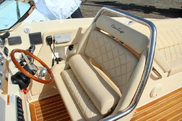Slide: The Image of 2017 Chris-Craft Launch 28 boat interior with beige leather seats and wooden steering wheel. - 7