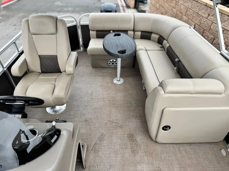 Slide: The Image of 2023 Sun Tracker Party Barge 20 DLX interior with beige seating and a small table. - 11