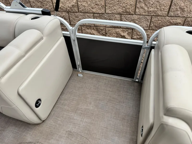 Slide: The Image of 2023 Sun Tracker Party Barge 20 DLX interior seating with beige upholstery and metal railing. - 13