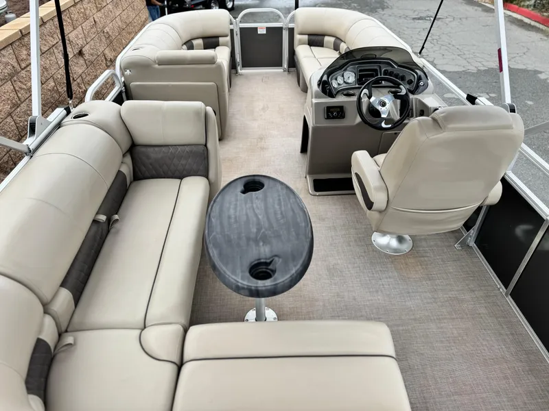 Slide: The Image of 2023 Sun Tracker Party Barge 20 DLX interior with beige seating and steering console. - 15