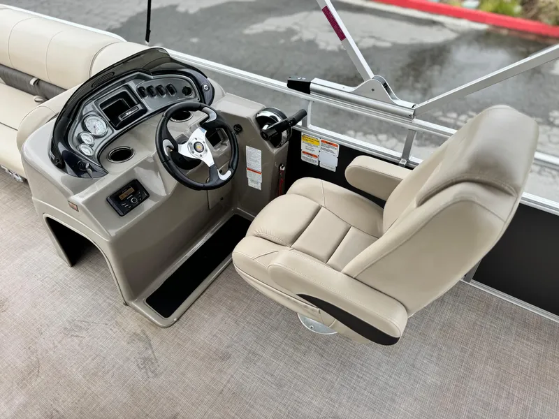 Slide: The Image of 2023 Sun Tracker Party Barge 20 DLX helm with beige captain's chair and control panel. - 16