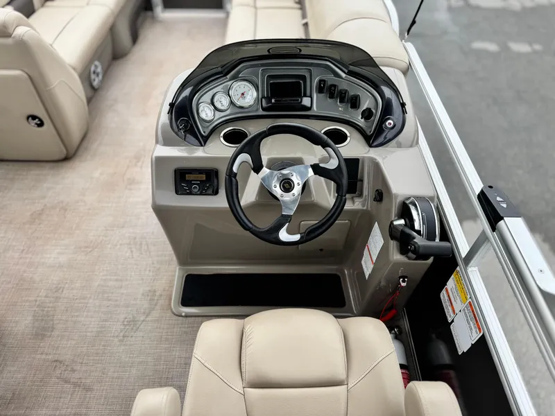Slide: The Image of 2023 Sun Tracker Party Barge 20 DLX helm with beige seating and modern controls. - 18
