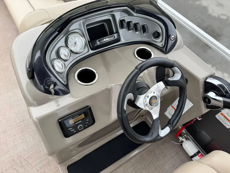 Slide: The Image of 2023 Sun Tracker Party Barge 20 DLX dashboard with steering wheel and gauges. - 19
