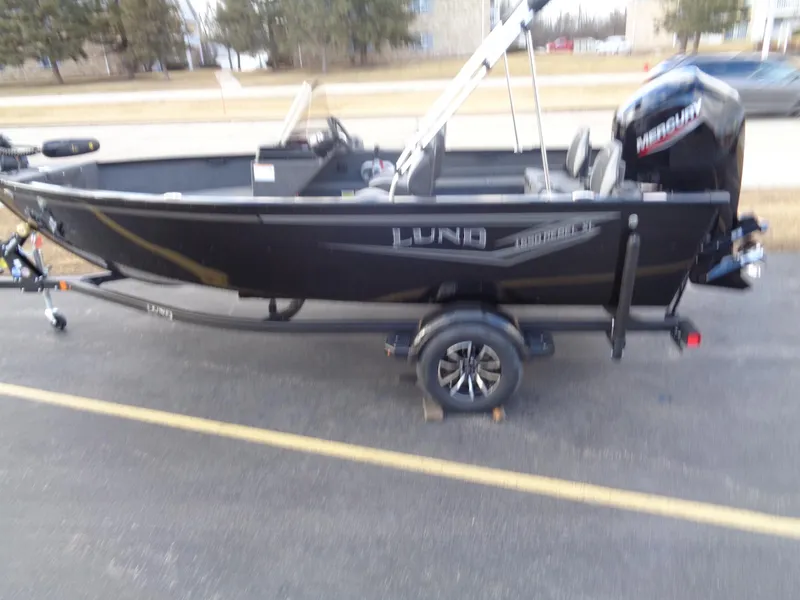 Slide: The Image of 2025 Lund 1650 Rebel XL SS boat on trailer, parked outdoors. - 3