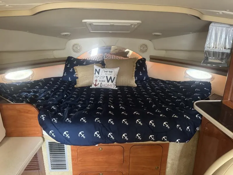 Slide: The Image of 2004 Rinker 342 Fiesta Vee cabin with anchor-themed bedding and decorative pillows. - 17