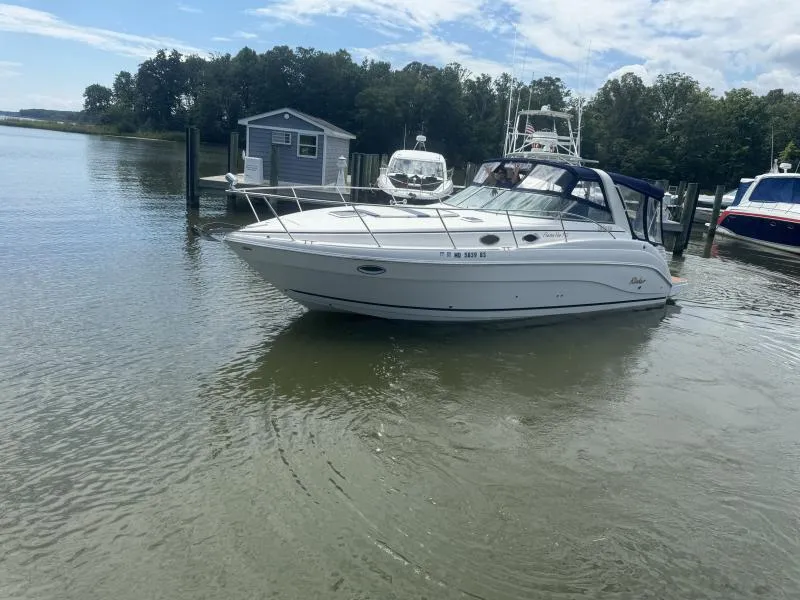 Slide: The Image of 2004 Rinker 342 Fiesta Vee boat docked on a calm lake under a partly cloudy sky. - 3