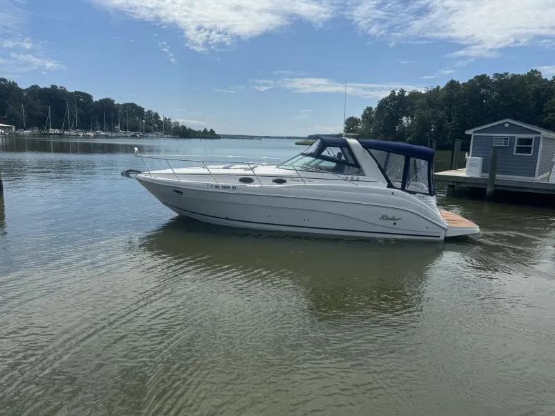 Slide: The Image of 2004 Rinker 342 Fiesta Vee boat docked on calm water under a partly cloudy sky. - 4