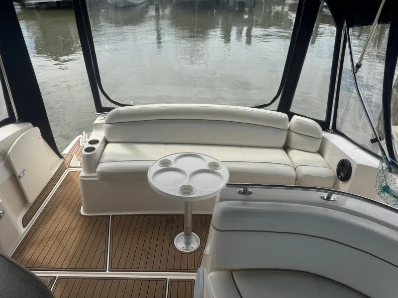 Slide: The Image of 2004 Rinker 342 Fiesta Vee boat interior with white seating and wooden flooring. - 8