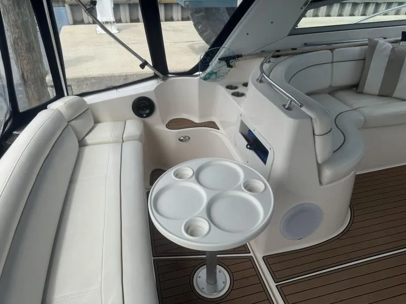 Slide: The Image of 2004 Rinker 342 Fiesta Vee boat interior with white seating and round table. - 9