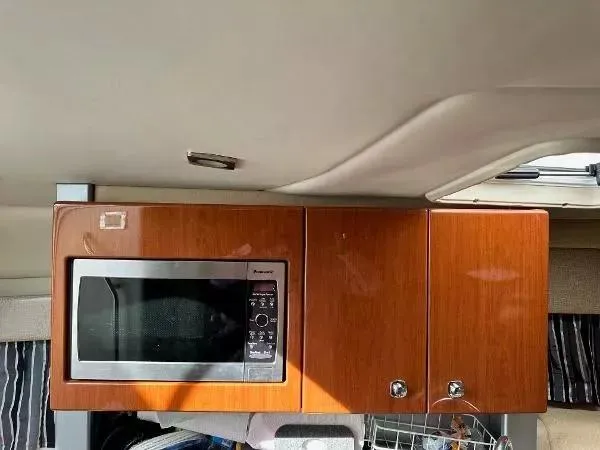 Slide: The Image of 2012 Formula 350 SS interior with wooden cabinets and built-in microwave. - 12