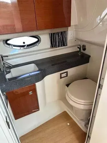 Slide: The Image of 2012 Formula 350 SS boat bathroom with sink, toilet, and wooden cabinetry. - 18