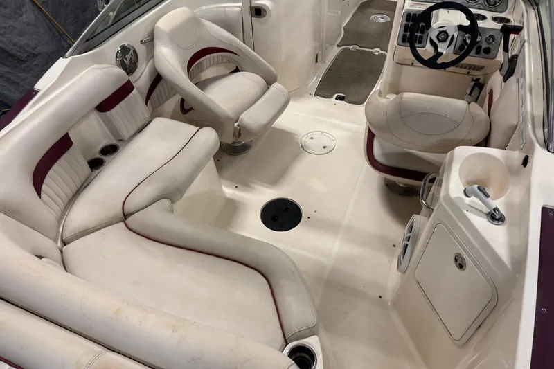 Slide: The Image of 2008 Hurricane SunDeck 2400 IO boat interior with white and maroon seating, steering console, and cup holders. - 19