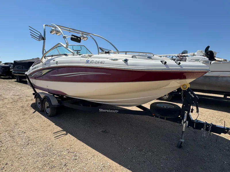 Slide: The Image of 2008 Hurricane SunDeck 2400 IO boat on trailer in indoor storage facility. - 2