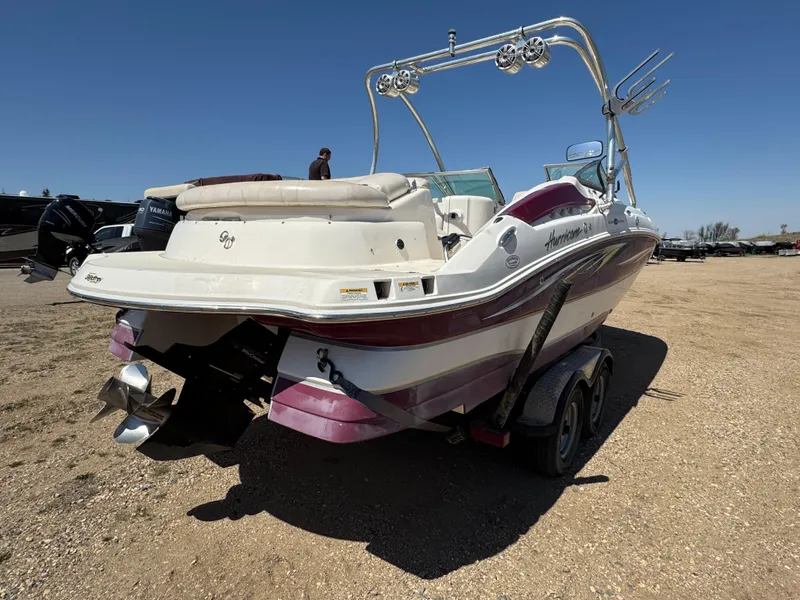 Slide: The Image of 2008 Hurricane SunDeck 2400 IO boat in a garage, featuring a maroon and white design. - 3