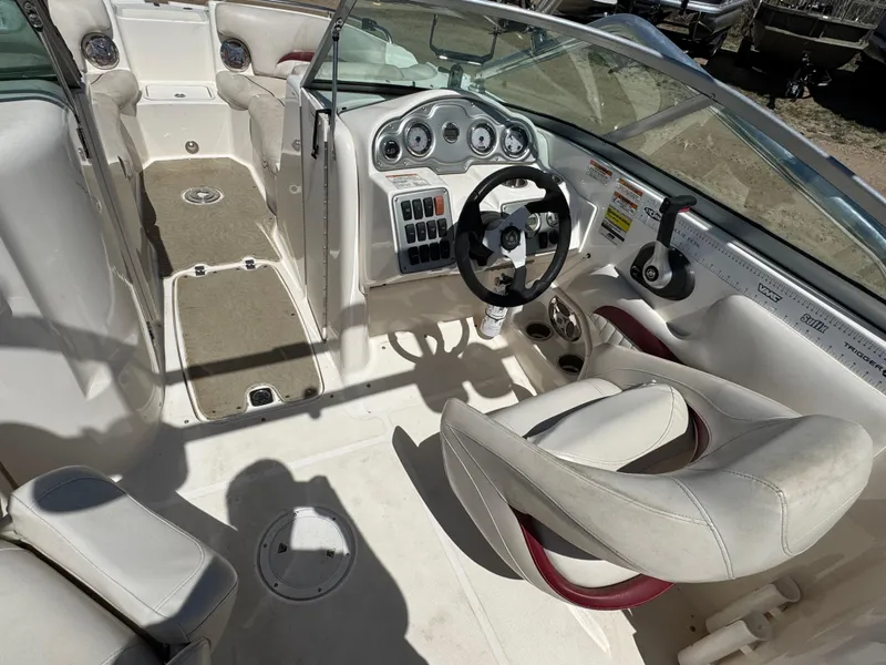 Slide: The Image of 2008 Hurricane SunDeck 2400 IO interior with white and maroon seating, dual consoles, and steering wheel. - 9