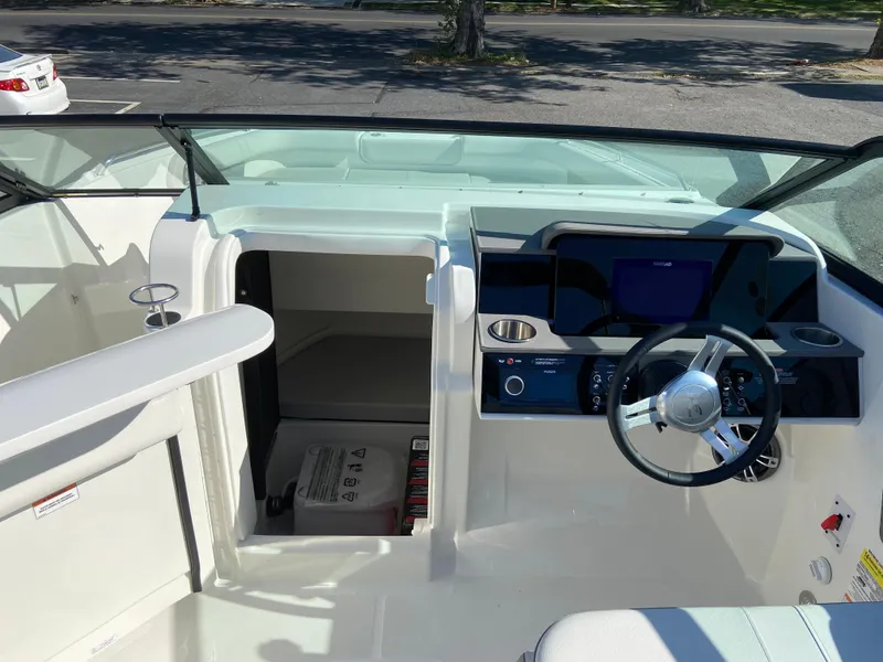 Slide: The Image of 2023 Sea Ray SDX 250 boat interior with steering wheel and cabin entrance. - 12