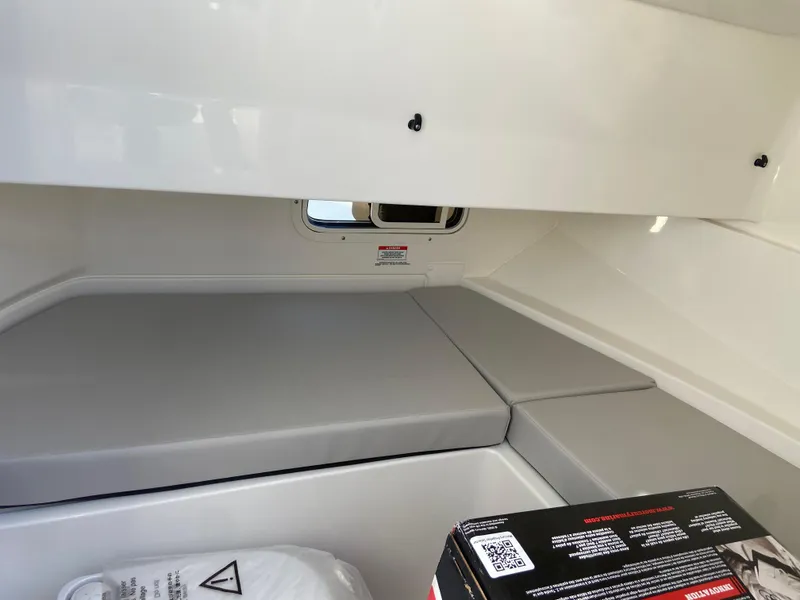 Slide: The Image of 2023 Sea Ray SDX 250 cabin interior with cushioned seating and storage space. - 13