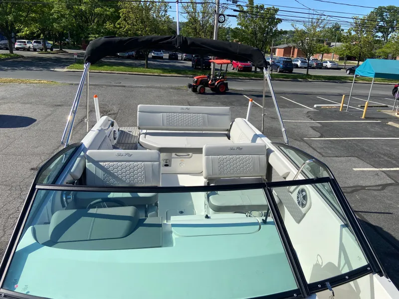 Slide: The Image of 2023 Sea Ray SDX 250 boat with spacious seating and canopy in a parking lot. - 15