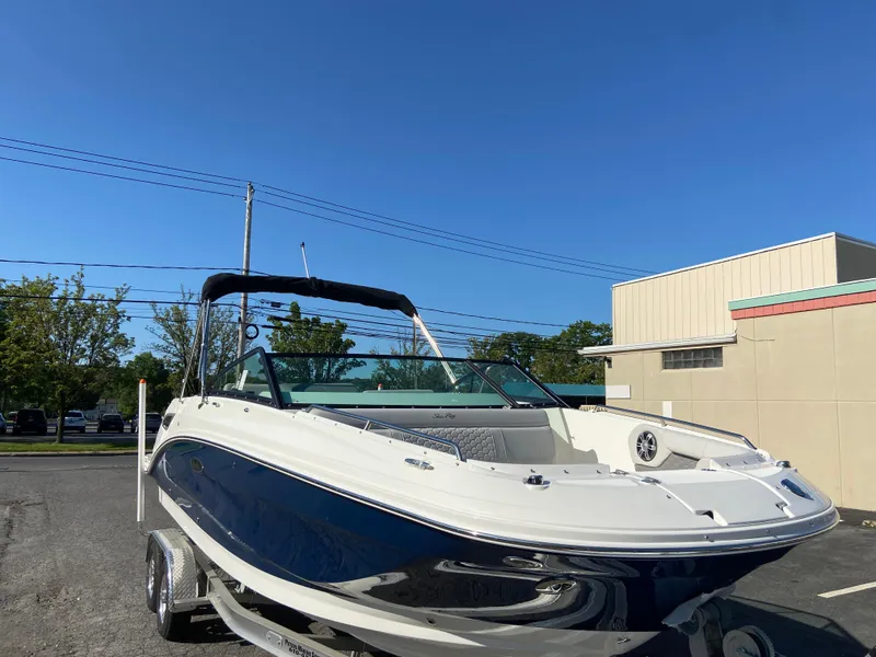 Slide: The Image of 2023 Sea Ray SDX 250 boat on trailer, parked outdoors under clear blue sky. - 3