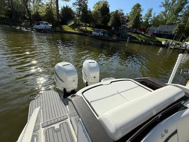 Slide: The Image of 2018 Sea Ray SLX 310 boat with twin Mercury outboard engines on a serene lake. - 10