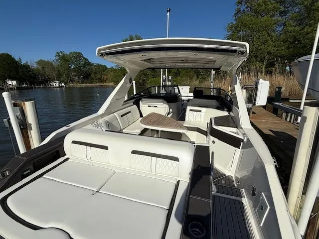 Slide: The Image of 2018 Sea Ray SLX 310 boat docked, featuring spacious seating and sleek design. - 9