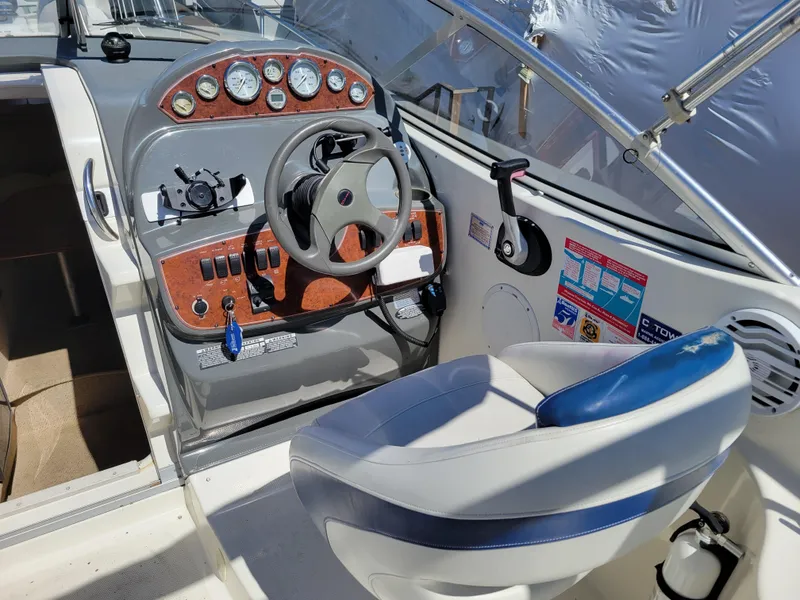 Slide: The Image of 2005 Bayliner 265 boat cockpit with steering wheel, control panel, and captain's chair. - 12