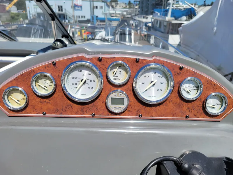 Slide: The Image of Dashboard of a 2005 Bayliner 265 boat with various gauges and controls. - 13