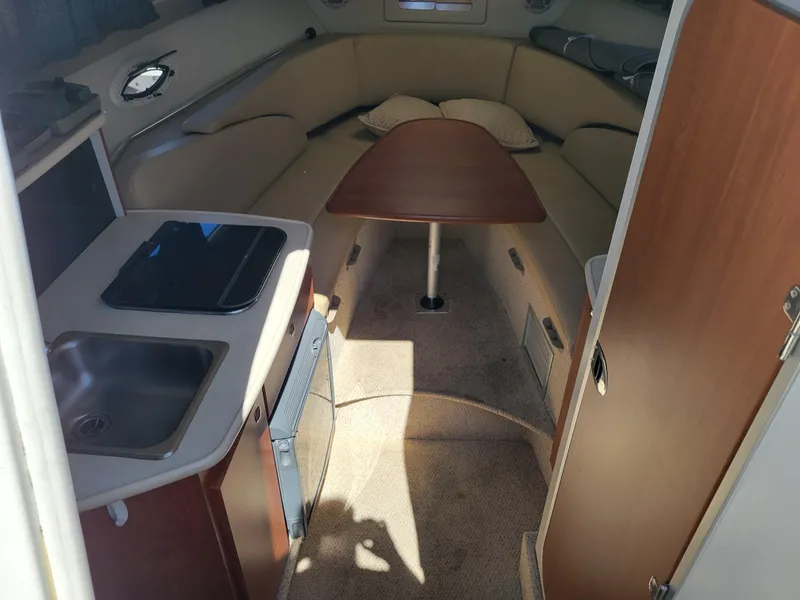 Slide: The Image of Interior of 2005 Bayliner 265 boat with kitchenette and seating area. - 18