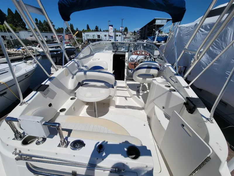 Slide: The Image of 2005 Bayliner 265 boat interior with seating and helm, docked at a marina. - 8