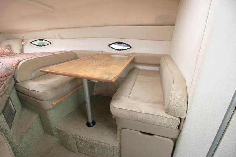 Slide: The Image of 1999 Maxum 2800 SCR boat interior with dining area and cushioned seating. - 14