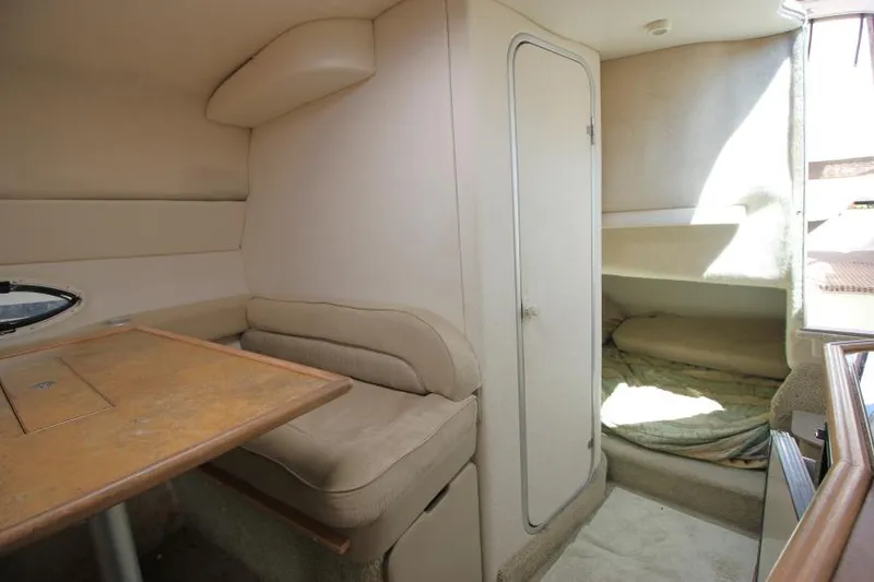 Slide: The Image of 1999 Maxum 2800 SCR cabin interior with seating, table, and sleeping area. - 18