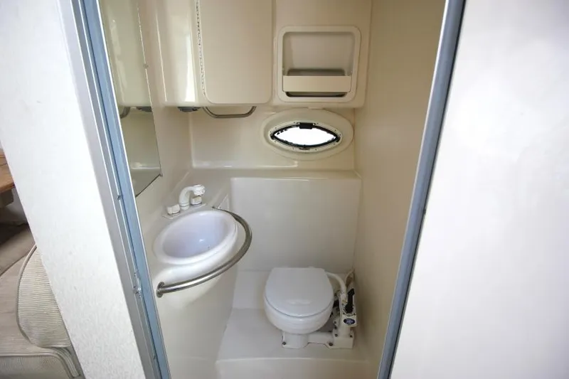 Slide: The Image of 1999 Maxum 2800 SCR boat bathroom with sink, toilet, and small window. - 19