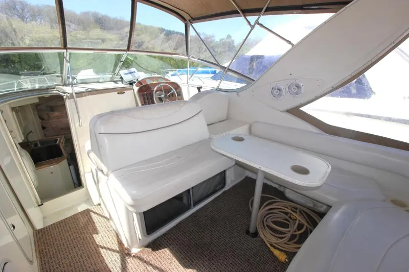 Slide: The Image of 1999 Maxum 2800 SCR boat interior with seating, table, and helm. - 7