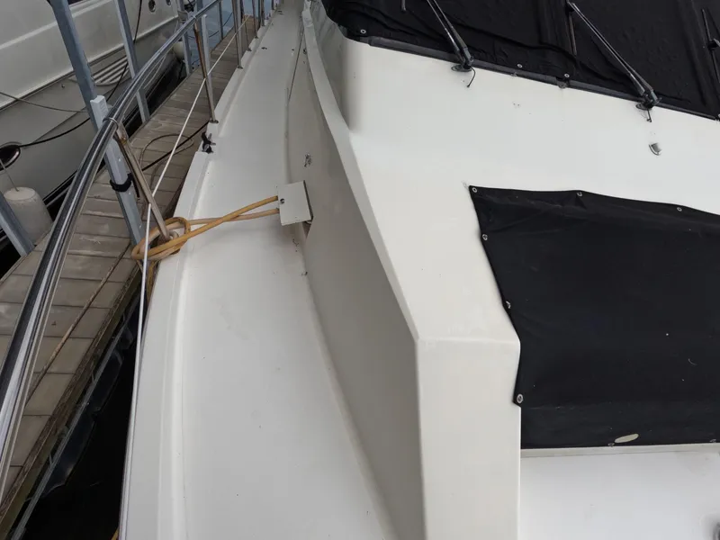 Slide: The Image of 1988 Viking Gulfstar 55 MY yacht deck with black cover and docked at marina. - 30