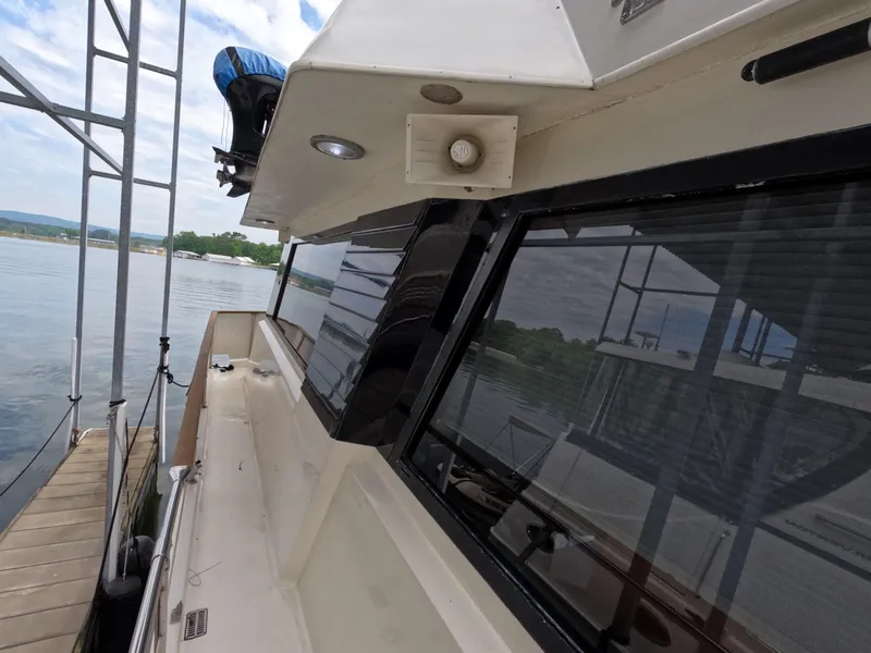 Slide: The Image of 1988 Viking Gulfstar 55 MY yacht docked, showcasing sleek design and reflective windows. - 34