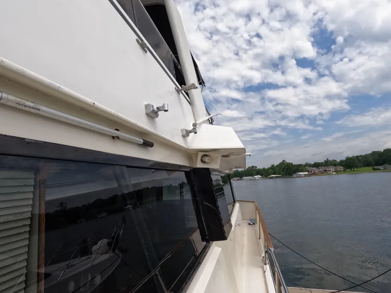Slide: The Image of 1988 Viking Gulfstar 55 MY yacht on a serene lake under a partly cloudy sky. - 40