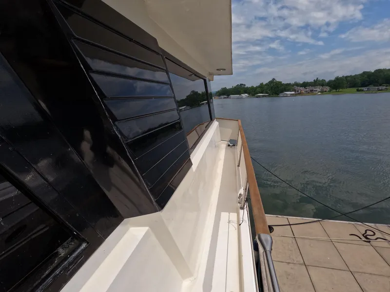 Slide: The Image of 1988 Viking Gulfstar 55 MY yacht docked by a serene lake under a partly cloudy sky. - 41