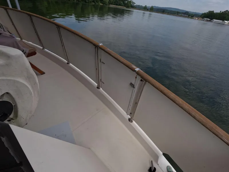 Slide: The Image of 1988 Viking Gulfstar 55 MY yacht deck with wooden railing, overlooking calm waters. - 42