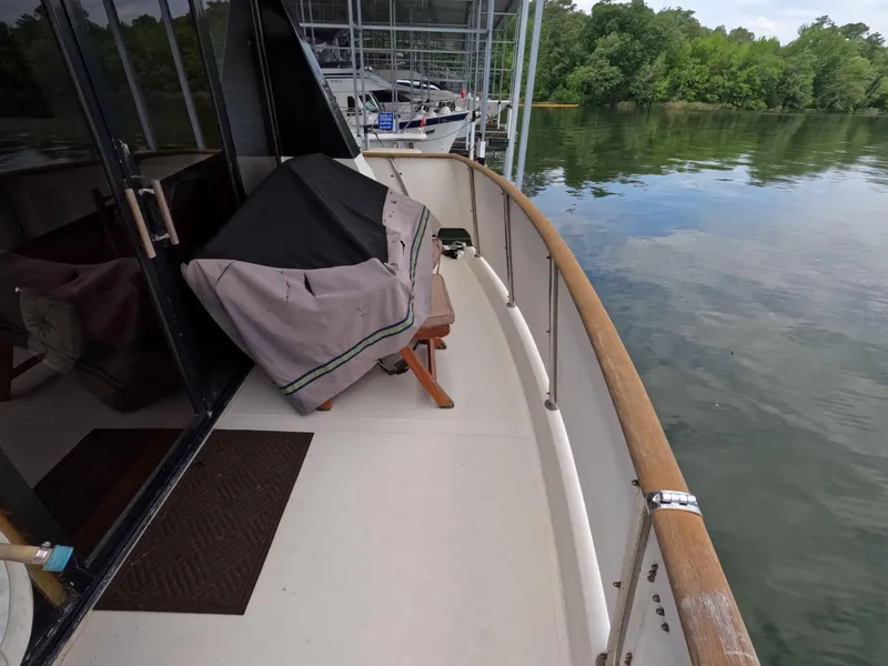 Slide: The Image of 1988 Viking Gulfstar 55 MY yacht deck with covered furniture, docked by calm waters. - 45