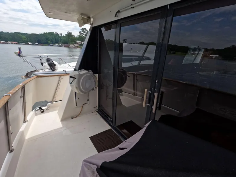 Slide: The Image of 1988 Viking Gulfstar 55 MY yacht deck with glass doors, overlooking serene lake view. - 48