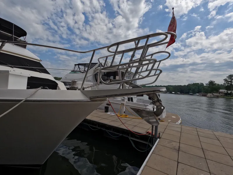 Slide: The Image of 1988 Viking Gulfstar 55 MY yacht docked by a scenic waterfront under a partly cloudy sky. - 9