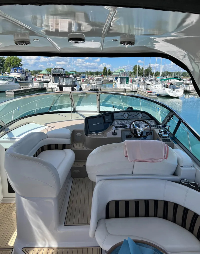 Slide: The Image of 2006 Four Winns 378 Vista yacht interior at marina, featuring helm and seating area. - 2