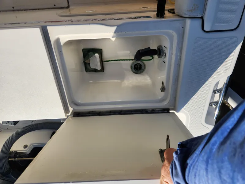 Slide: The Image of 2004 Pursuit 2470 Center Console storage compartment with open lid and visible equipment. - 14