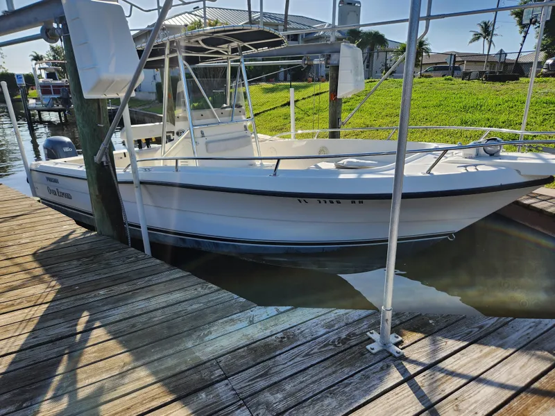 Slide: The Image of 2004 Pursuit 2470 Center Console boat docked in sunny marina setting. - 15