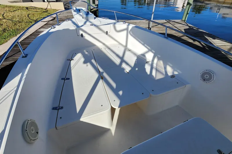 Slide: The Image of 2004 Pursuit 2470 Center Console boat interior with seating and railings by the water. - 19